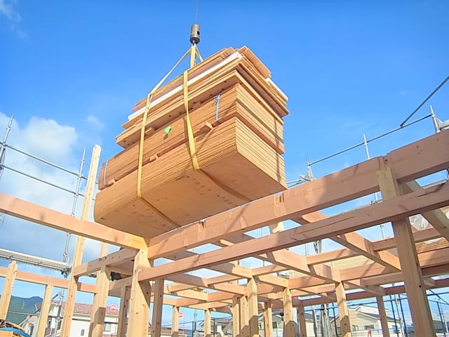 建設現場での木材のクレーン作業