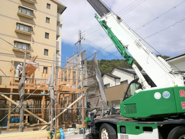 木造建築の現場で作業中のクレーン