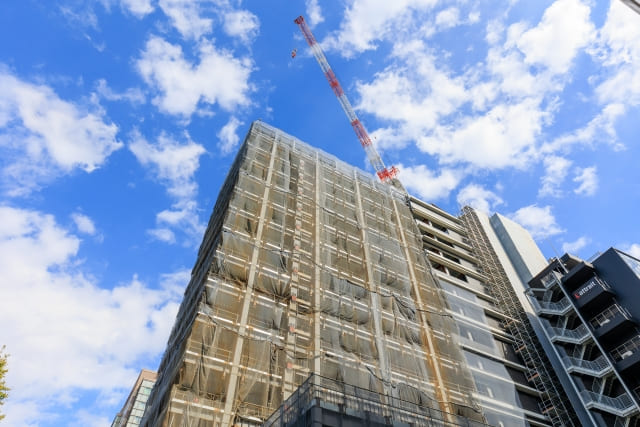 青空にそびえる高層ビルの建設現場