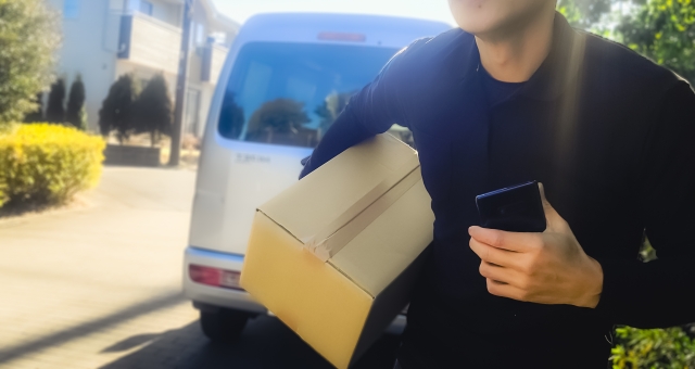 配送トラックに荷物を運ぶ男性